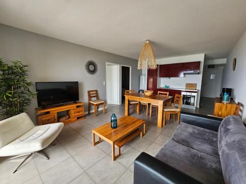 uma sala de estar com um sofá e uma sala de jantar em Résidence Pasino em Lacanau-Océan