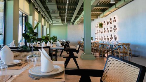 a restaurant with tables and chairs in a room at Kronos Hotel in Durrës
