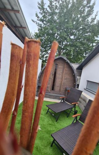 a fence with two chairs and a table and a cabin at Schlaffass mit Wellness in alter Scheune in Seinsheim