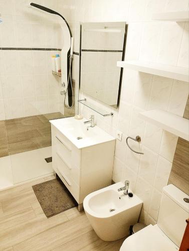 a white bathroom with a sink and a toilet at RESIDENCIA TORTUGA MORA in Calabardina