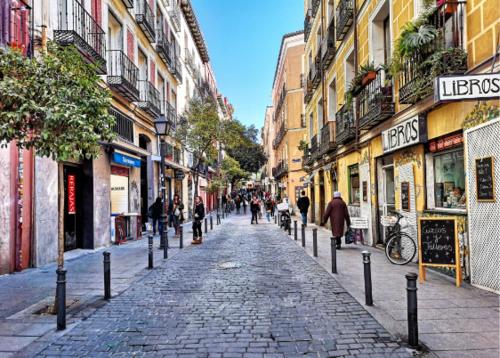 una calle adoquinada en una ciudad con gente caminando en Coqueto Estudio en Malasaña, en Madrid