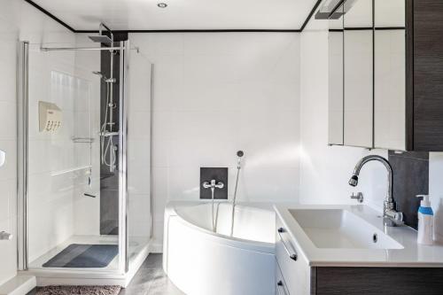 baño blanco con ducha y lavamanos en Ferienhaus Ihme, en Sande