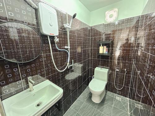 a bathroom with a shower and a toilet and a sink at D'Village Homestay Kota Bharu in Kota Bharu