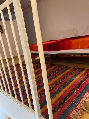 a bunk bed on a ladder with a rug at Appart-hotel la lune du desert in Erfoud