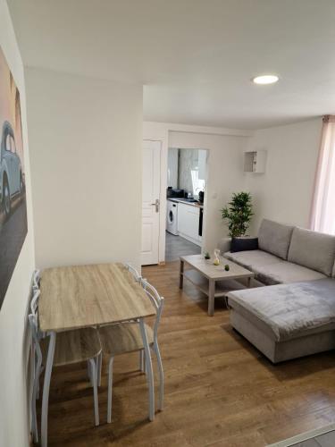 un salon avec un canapé et une table dans l'établissement Appartement Hyper Centre Cosy avec Balcon, à Châteaudun
