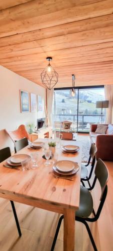- une table en bois dans une pièce avec salle à manger dans l'établissement The White Bear - Appartement Spacieux et Confortable, à La Clusaz