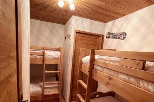 Cette chambre comprend 2 lits superposés et une porte. dans l'établissement The White Bear - Appartement Spacieux et Confortable, à La Clusaz