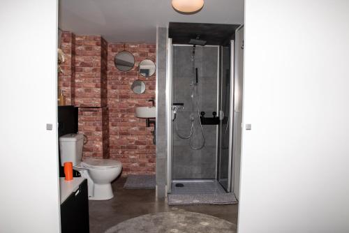 a bathroom with a shower with a brick wall at L'écurie gîte chambre in Spa