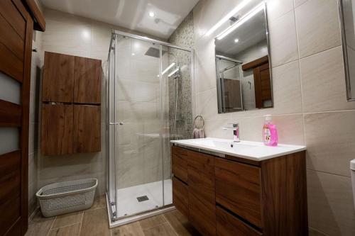 ein Bad mit einer Dusche, einem Waschbecken und einem Spiegel in der Unterkunft Lovely apartment by the sea. MF1 in St Paul's Bay