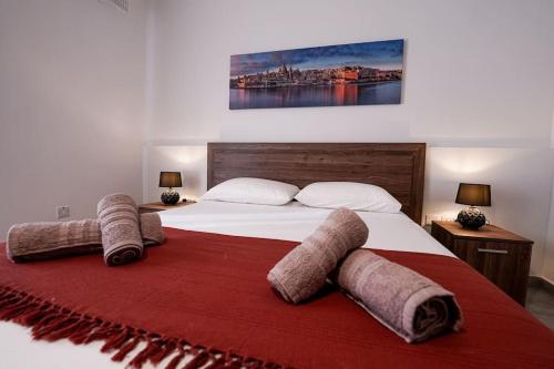 ein Schlafzimmer mit einem großen Bett mit Handtüchern darauf in der Unterkunft Lovely apartment by the sea. MF1 in St Paul's Bay
