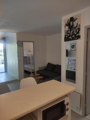 un salon avec un canapé et une table dans l'établissement Résidence les caraïbes Cap d'agde - Centre Port- Parking Gratuit-Terrasse - wifi 5G, au Cap d'Agde