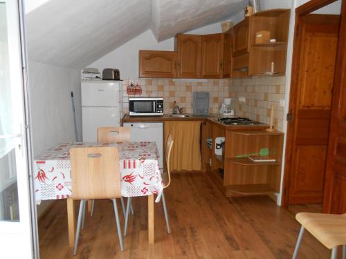 una pequeña cocina con mesa y sillas. en location MIRANDE 2 chambres 4 couchages, en Laruns