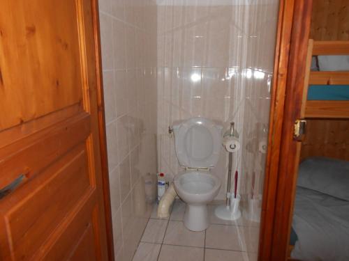location MIRANDE 2 chambres 4 couchages 9 rue de SOUPON في لارونس: حمام به مرحاض وجدار من البلاط