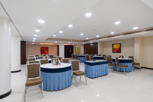 a conference room with blue tables and chairs at 37th Crescent Hotel Bengaluru in Bengaluru