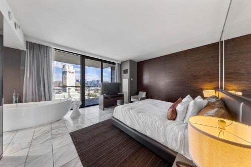 a bedroom with a tub and a bed and a television at Modern Luxury 17 Floor Panoramic Huge Corner Suite in Las Vegas