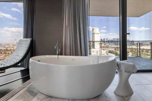 a white bath tub in a bathroom with a large window at Modern Luxury 17 Floor Panoramic Huge Corner Suite in Las Vegas
