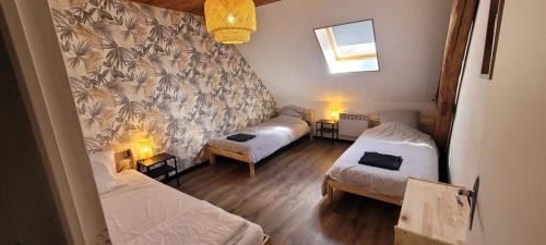 a small room with two beds and a wall at Gîte cozy proche du Zoo de Beauval / Châteaux de la Loire N1 in Selles-sur-Cher