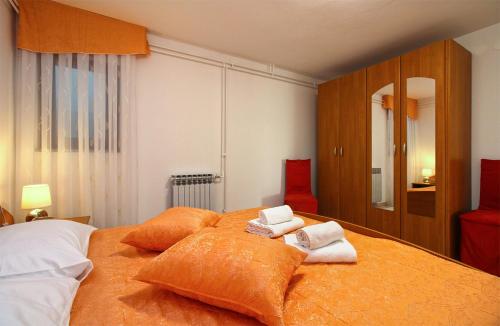 a bedroom with a large bed with towels on it at Apartments Slavko 1179 in Banjole