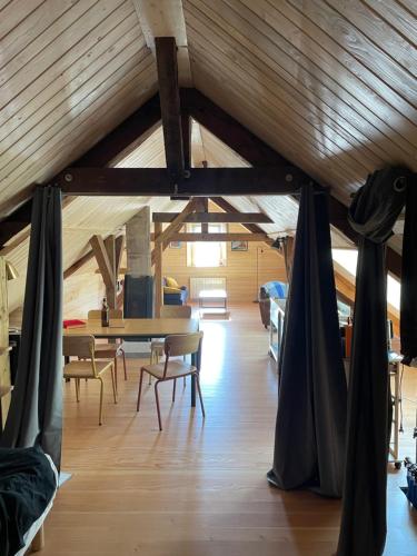 MeisenthalにあるMon refuge en Vasgovieの木製の天井、テーブル、椅子が備わる客室です。