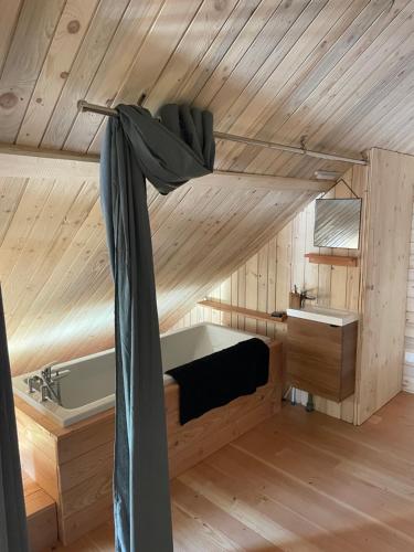 a room with a bed and a tub in a cabin at Mon refuge en Vasgovie in Meisenthal