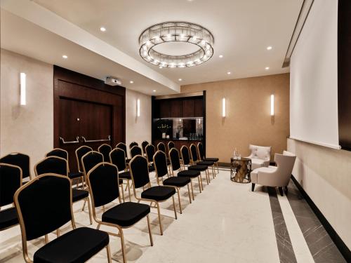 a conference room with a row of chairs and a podium at The Crown Krakow Center - Handwritten Collection ACCOR in Kraków