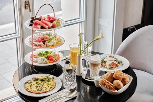 a table topped with plates of food and drinks at The Crown Krakow Center - Handwritten Collection ACCOR in Kraków