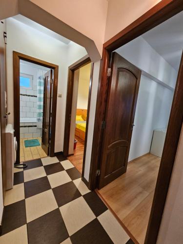 a hallway with doors and a checkerboard floor at Cosy apartment close to City Center with parking lot in Bucharest