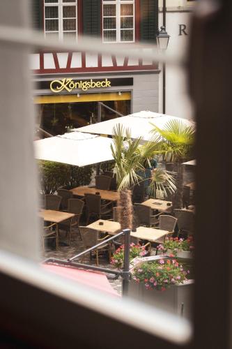 a view from a window of a restaurant with tables and umbrellas at JACOB 1808. fine historic town apartments in Bischofszell
