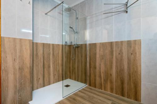 La salle de bains est pourvue d'une douche avec une porte en verre. dans l'établissement La Garrofera, à Aldover