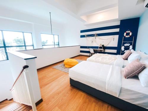 two beds in a room with blue and white walls at Kuantan Imperium by Glex in Kuantan