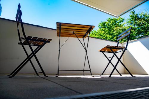 2 chaises en bois assises à côté d'un mur dans l'établissement T3 -4 km Aéroport Orly-proche T7, à Rungis