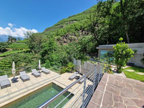 a house with a swimming pool and a mountain at Videre Penthouse Lodge in Gargazzone