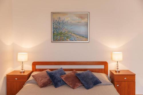 een slaapkamer met een bed met 2 lampen en een schilderij aan de muur bij Holiday apartment in Seget Vranjica with sea view, terrace, WiFi, washing machine 5181-2 in Seget Vranjica