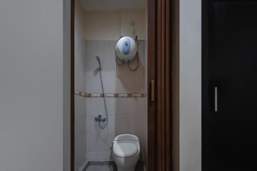 a bathroom with a toilet and a shower at Cove Oekude Residence in Jakarta