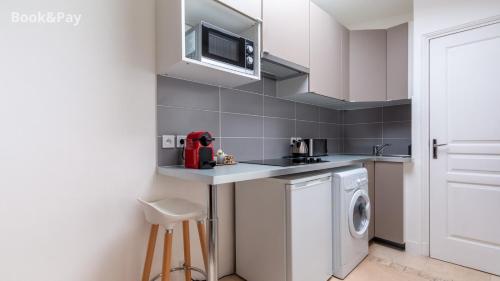 une cuisine avec un évier et une machine à laver dans l'établissement Nid d'amour, à Paris