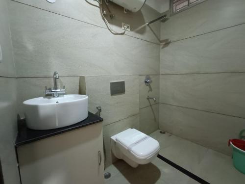 a bathroom with a sink and a toilet at Hotel Satyam in Jaigaon