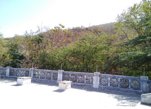 a stone fence with trees in the background at Hotel HillView, Junagadh in Junagadh