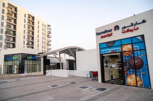 a store with a sign on the side of a building at Yas Escape - Stylish Boho Studio with Pool, Near Yas Mall in Abu Dhabi