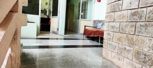 a hallway with a bed and a brick wall at Hotel HillView, Junagadh in Junagadh