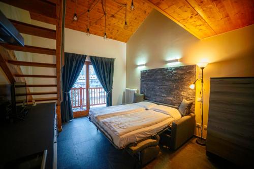 a bedroom with a bed and a brick wall at Alta Luce Mountain Lodge in Gressoney-la-Trinité