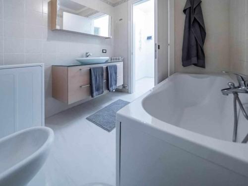 un bagno bianco con vasca e lavandino di Appartamento Diamante a Gorizia
