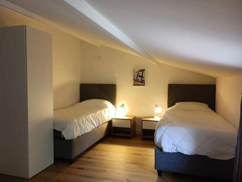 - une chambre avec 2 lits et 2 lampes sur les tables dans l'établissement Maison/appartement proche Cala Rossa, à Lecci