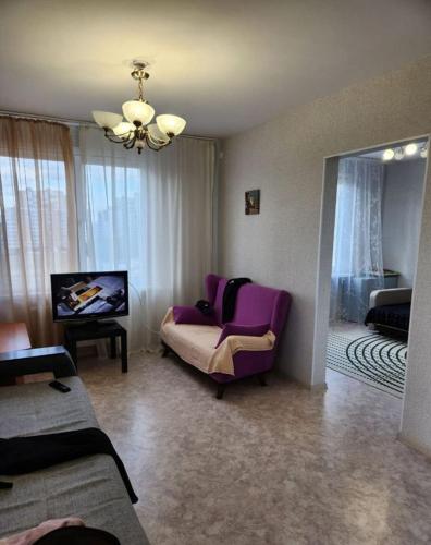 Sala de estar con silla morada y espejo en Old City centre modern style apartment, en Tashkent