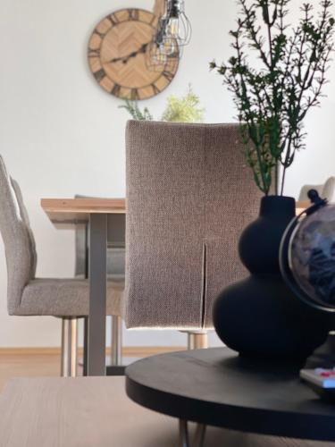 a table with a chair and a vase on a table at Gemütliche, helle Wohnung in Paderborn in Paderborn