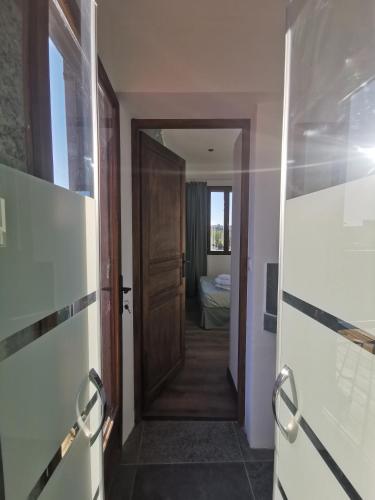 un couloir avec une porte menant à une chambre dans l'établissement La Terrasse suspendue des Arènes - Une Nuit à Nîmes, à Nîmes