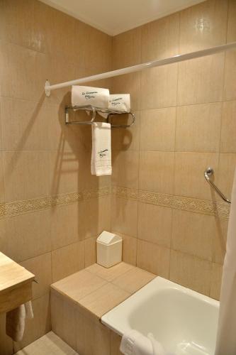 a bathroom with a tub and a sink and towels at La Campiña Club Hotel & Spa in Santa Rosa