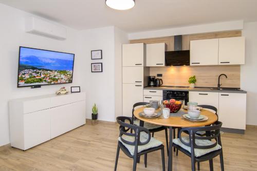 a kitchen and dining room with a table and chairs at Apartments & Rooms Darrer in Poreč