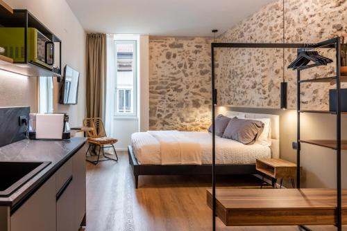 um quarto de hotel com uma cama e uma cozinha em The Place - Only Self Check-in - No Reception em Trento