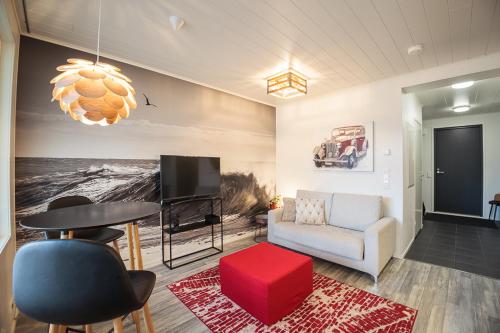 een woonkamer met een bank, een tafel en een tv bij Tahkokorva Studios by Hiekka Booking in Kalajoki