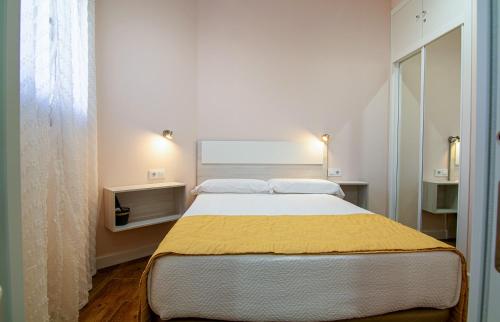a bedroom with a large bed with a yellow blanket at ALOJAMIENTOS TAJO INTERNACIONAL in Alcántara
